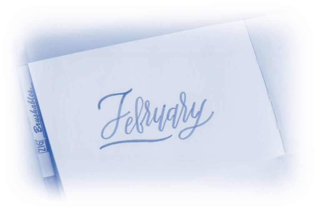A softly illuminated page with the word February elegantly handwritten and a white pen lying diagonally on it, highlighting PPC News February 2024.