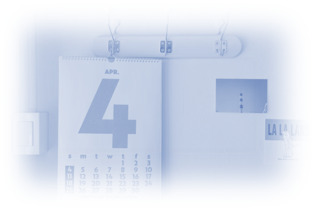 A minimalist April 2024 calendar hanging on a wall with the number 4 prominently displayed, a light switch to the left, and a small picture of a lighthouse on the wall, alongside a LA LA LAND poster.
